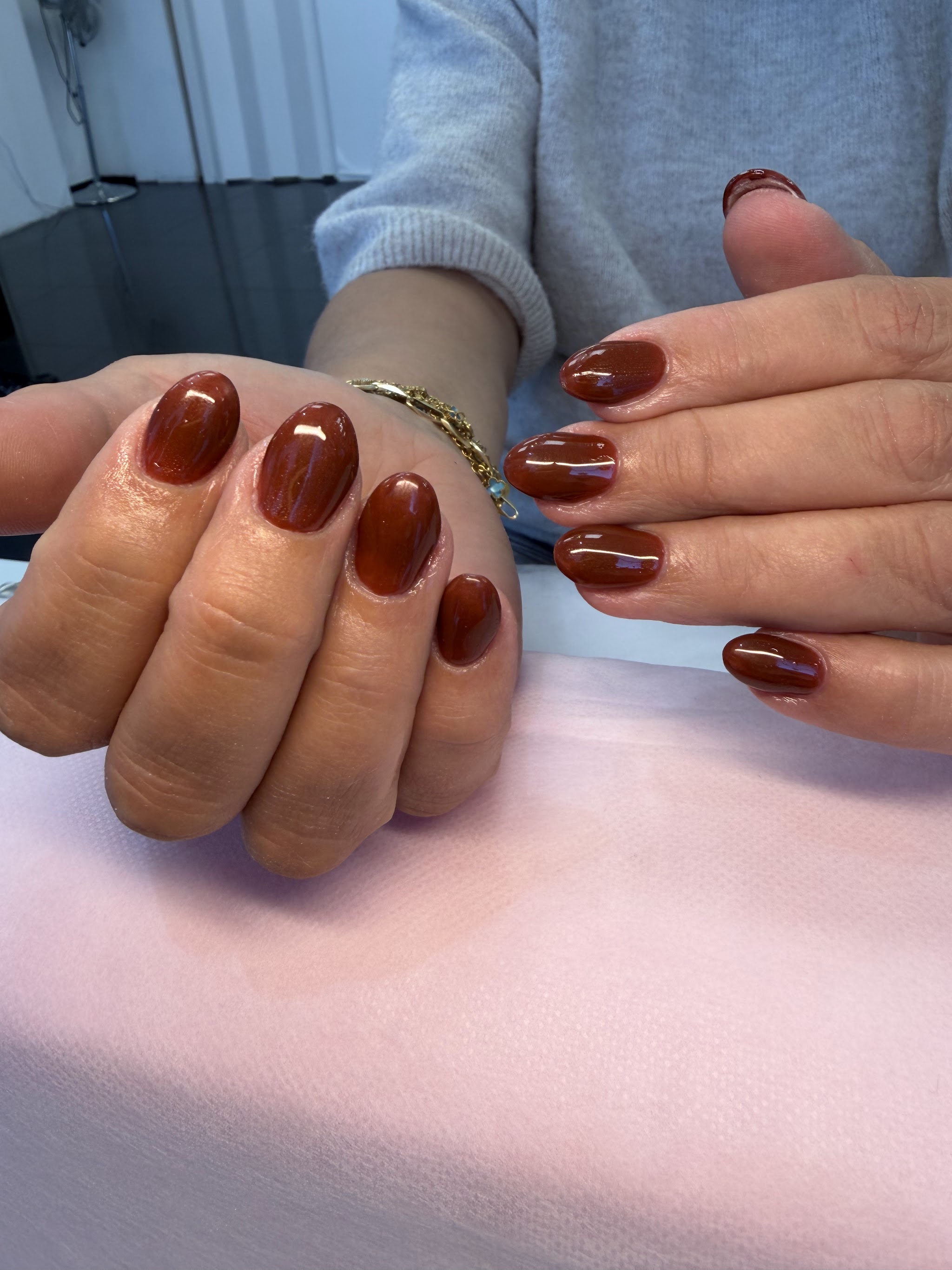 Glanzende bruine nagels op een roze handdoek